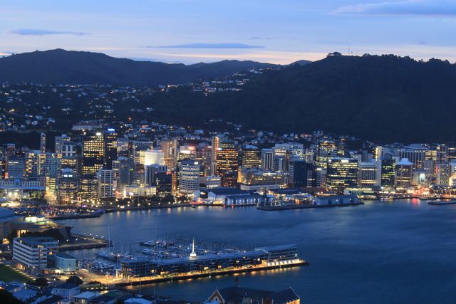 Wellington, capital de Nueva Zelanda Vista nocturna de Wellington, capital de Nueva Zelanda, con la bahía, edificios iluminados y montañas alrededor.
