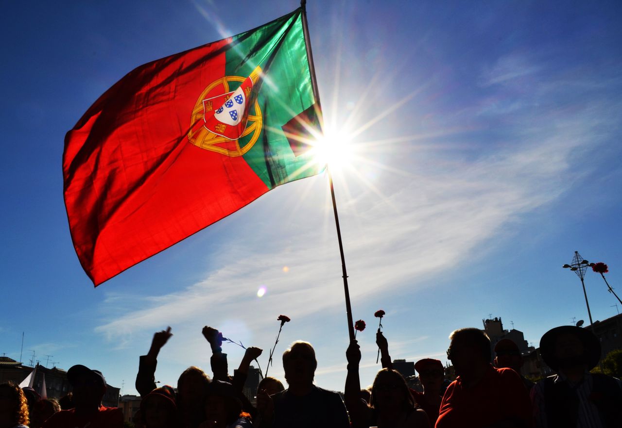 Bandera de Portugal ondeando al sol, imagen relacionada con una guía sobre dónde queda Portugal y qué saber antes de viajar.