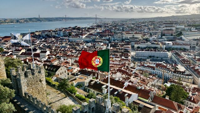 Lisboa, capital de Portugal frente al río Tajo Vista panorámica de Lisboa, capital de Portugal, con la bandera portuguesa y el río Tajo al fondo.