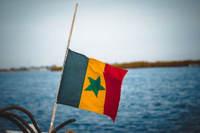 Bandera de Senegal, país de África occidental Bandera de Senegal frente al agua, imagen relacionada con una guía sobre dónde queda Senegal y qué saber antes de viajar.