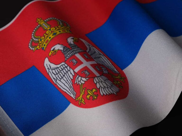 Bandera de Serbia con su escudo nacional, imagen relacionada con una gu&iacute;a sobre d&oacute;nde queda Serbia en Europa.