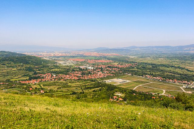 Paisaje rural de Serbia con colinas verdes, pueblos y campos, imagen relacionada con una guía sobre dónde queda Serbia y qué ver.