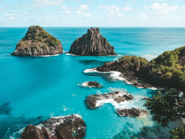 Vista de Fernando de Noronha con mar turquesa, formaciones rocosas y costa volcánica, una de las islas más lindas del mundo.