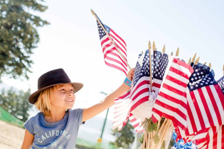 Ni&ntilde;o con peque&ntilde;as banderas de Estados Unidos durante una celebraci&oacute;n del Fourth of July, imagen relacionada con d&oacute;nde vivir el D&iacute;a de la Independencia.