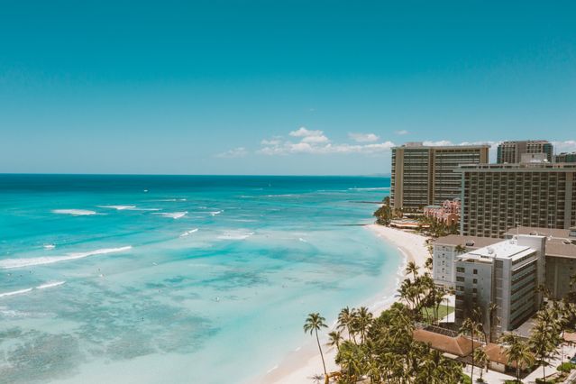 Playa de Waikiki en Oahu, Hawaii, con aguas turquesas, palmeras y hoteles frente al océano Pacífico.