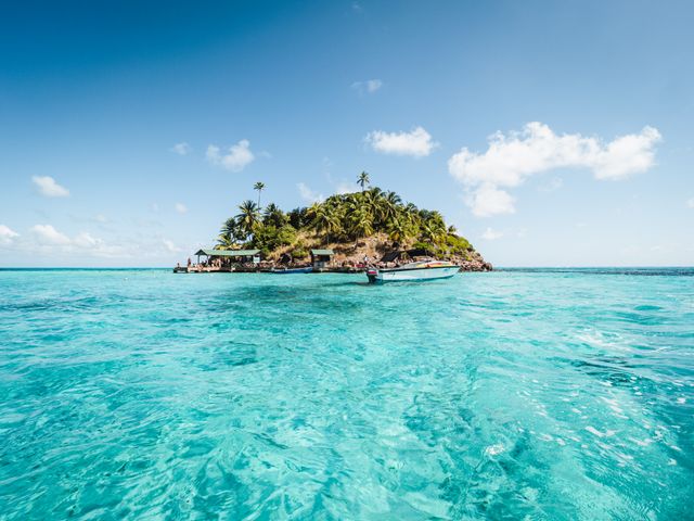Islas más lindas del mundo: destinos paradisíacos para viajar al menos una vez Pequeña isla paradisíaca rodeada de aguas turquesas y palmeras, una imagen representativa de algunos de los destinos insulares más lindos del mundo.
