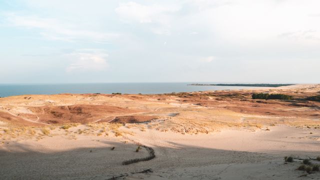 Istmo de Curlandia: una de las grandes playas y franjas de arena de Europa Paisaje de dunas y costa en el istmo de Curlandia, una extensa franja de arena junto al mar Báltico.