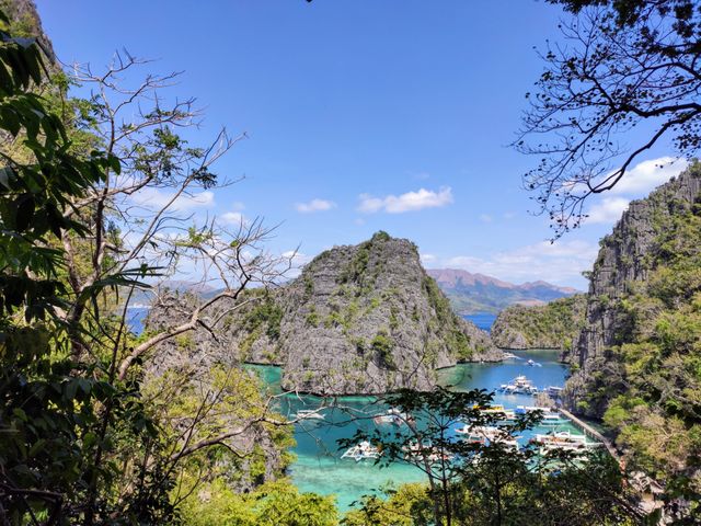 Paisaje de Palawan con laguna turquesa, formaciones rocosas y embarcaciones, una de las islas más lindas del mundo.