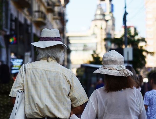 Pareja de adultos mayores caminando por una ciudad durante un viaje, imagen relacionada con paquetes turísticos para jubilados en 2026.