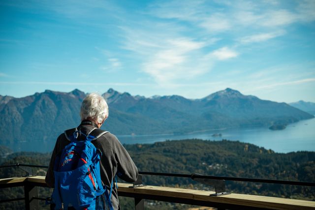 Persona mayor contemplando un paisaje de lagos y montañas en la Patagonia argentina, imagen relacionada con paquetes de viajes para jubilados en 2026.