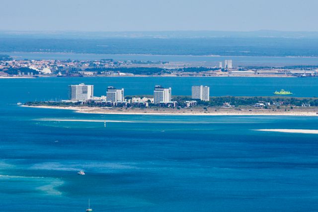 Troia, en Portugal: una de las playas largas más atractivas de Europa Vista panorámica de Troia, en Portugal, con una larga franja de arena, mar azul y edificios junto a la costa.