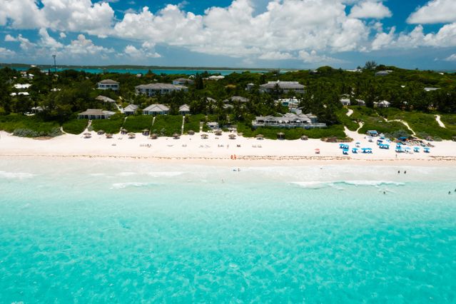 Vista aérea de Providenciales con playa de arena blanca y mar turquesa, una de las islas más lindas del mundo.