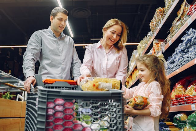 Familia comprando productos en un supermercado durante un viaje, una experiencia vinculada al turismo de supermercado.