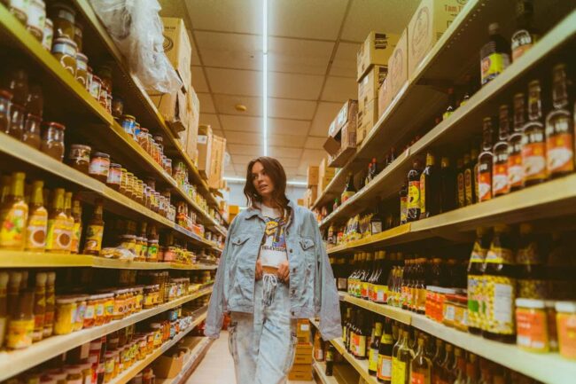 Viajera recorriendo los pasillos de un supermercado con productos locales, una experiencia vinculada al turismo de supermercado.