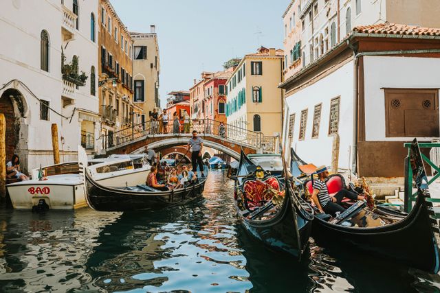 Góndolas con turistas en un canal de Venecia, imagen relacionada con la posible suba de la tarifa de entrada para visitar la ciudad.