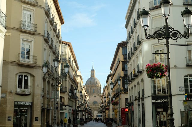 Calle del centro histórico de Zaragoza con vista a la Basílica del Pilar, uno de los lugares clave durante las Fiestas del Pilar.