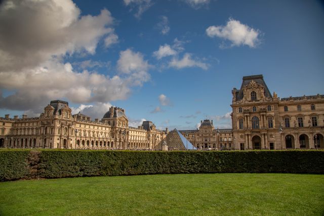 Alojarse cerca del Louvre en París por primera vez Museo del Louvre en París con su pirámide de cristal, jardines y edificios históricos, una zona conveniente para alojarse por primera vez.