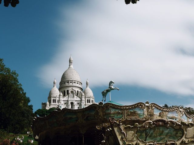 Basílica del Sacré-Cœur en Montmartre, París, con un carrusel en primer plano y cielo despejado.