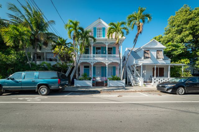 Casas históricas de colores rodeadas de palmeras en una calle de Key West, Florida.