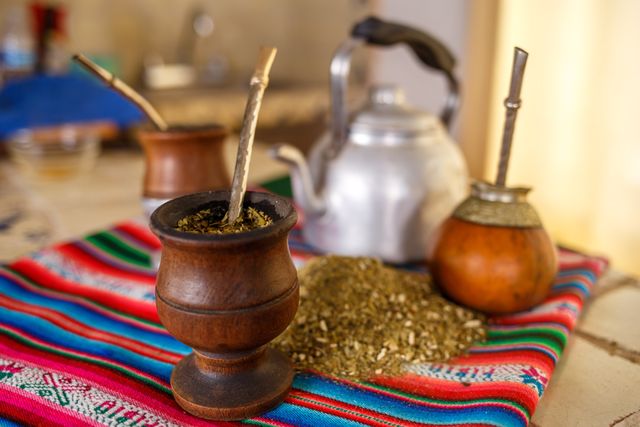 Mates argentinos con yerba mate sobre un tejido colorido, imagen relacionada con las comidas y bebidas típicas de Argentina por región.