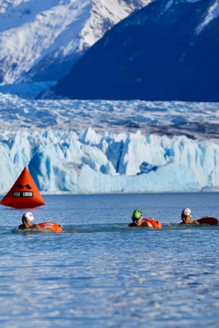 Nadadores compiten en aguas frías frente al glaciar Perito Moreno durante un evento de natación de invierno en la Patagonia.