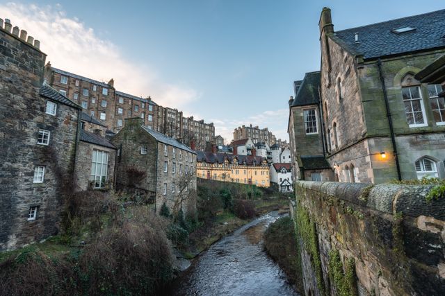 Edimburgo histórica: calles de piedra y barrios pintorescos de Escocia Calles históricas de Edimburgo con edificios de piedra y un arroyo, imagen relacionada con la capital de Escocia.