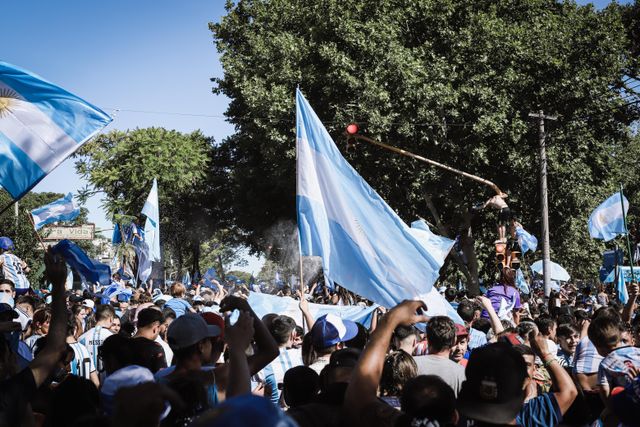 Hinchas argentinos con banderas celestes y blancas celebrando en la calle, imagen relacionada con el Mundial 2030 y los viajes de fútbol.