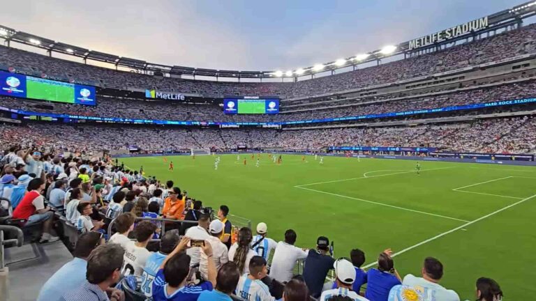 Interior del MetLife Stadium durante un partido de fútbol con tribunas llenas, sede de la final del Mundial 2026 en Nueva York–Nueva Jersey.