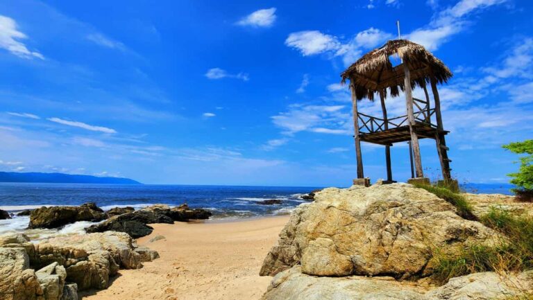 Playa rocosa cerca de Puerto Vallarta con palapa de madera frente al oc&eacute;ano Pac&iacute;fico mexicano.