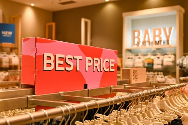 Precios bajos y ofertas en Primark Estados Unidos Cartel de “best price” en una tienda de ropa con sección de bebé, imagen relacionada con los precios de Primark en Estados Unidos.