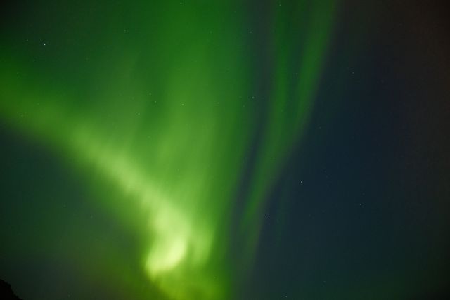 Aurora boreal de color verde iluminando el cielo nocturno de Islandia.
