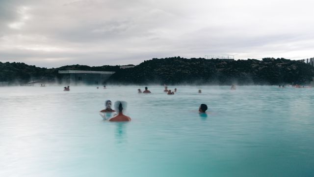Visitantes bañándose en las aguas geotermales de Blue Lagoon, Islandia, rodeadas de campos de lava.