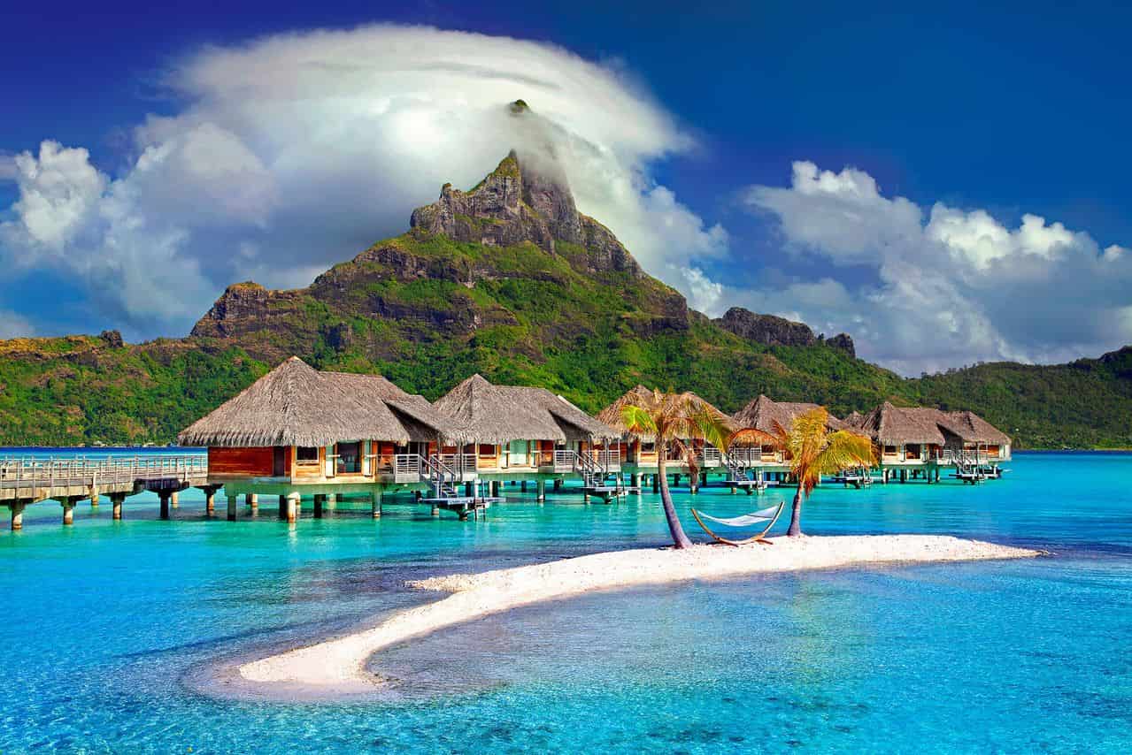 Bungalows sobre el agua frente al monte Otemanu en Bora Bora, Polinesia Francesa