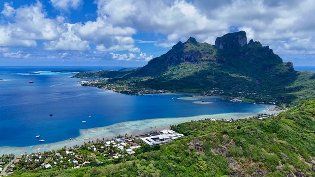 Vista aérea de Bora Bora con su laguna azul, montañas y costa tropical en la Polinesia Francesa