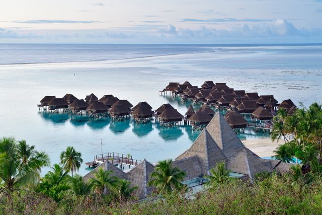 Bungalows sobre el agua en una laguna turquesa de Bora Bora, Polinesia Francesa