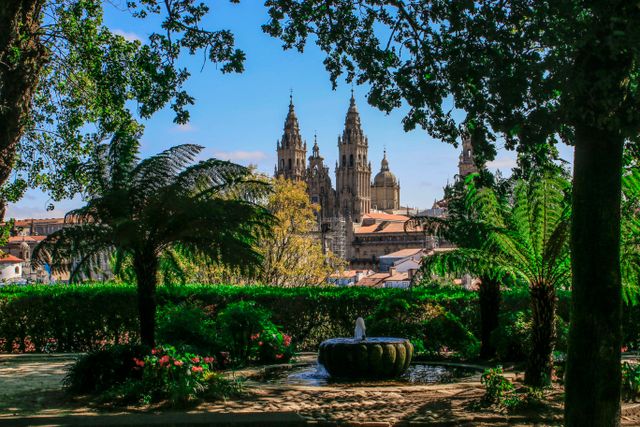 Catedral de Santiago de Compostela vista entre los árboles desde un parque de la ciudad, en Galicia, España.