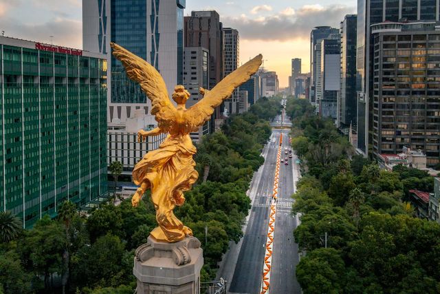 Ángel de la Independencia sobre Paseo de la Reforma en Ciudad de México, con edificios del centro financiero al fondo.