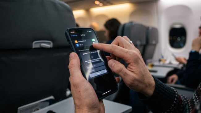 Cómo conectarse al WiFi de un avión Pasajero conectando su teléfono al WiFi de un avión durante el vuelo