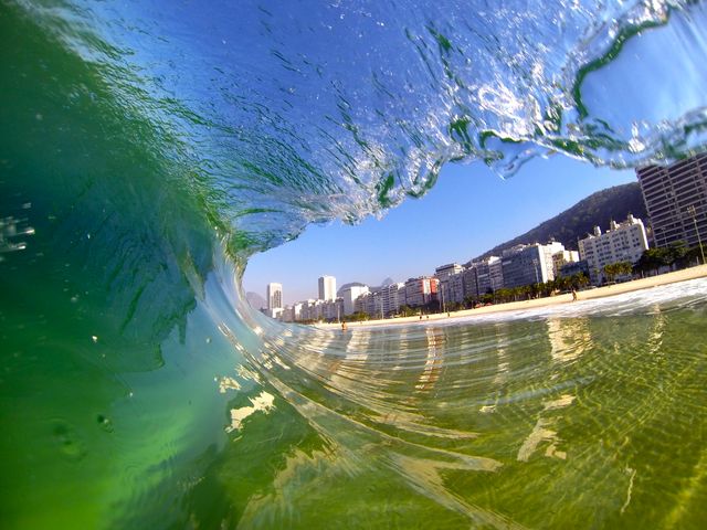 Playa de Copacabana en un viaje a Río de Janeiro con niños Ola rompiendo frente a la playa de Copacabana, en Río de Janeiro, con edificios de la costanera al fondo.