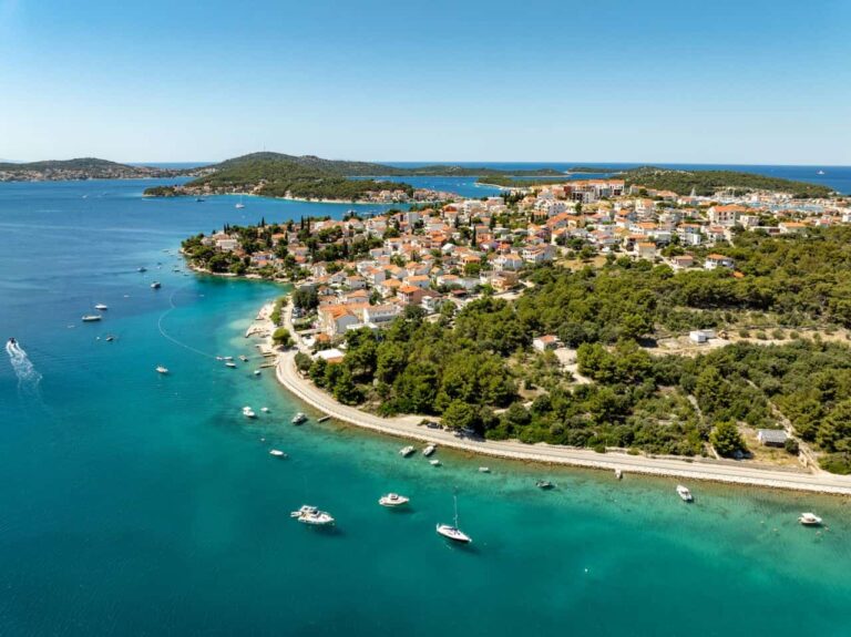 Vista a&eacute;rea de una localidad costera de Croacia rodeada de aguas turquesas, peque&ntilde;as islas y embarcaciones en el mar Adri&aacute;tico.