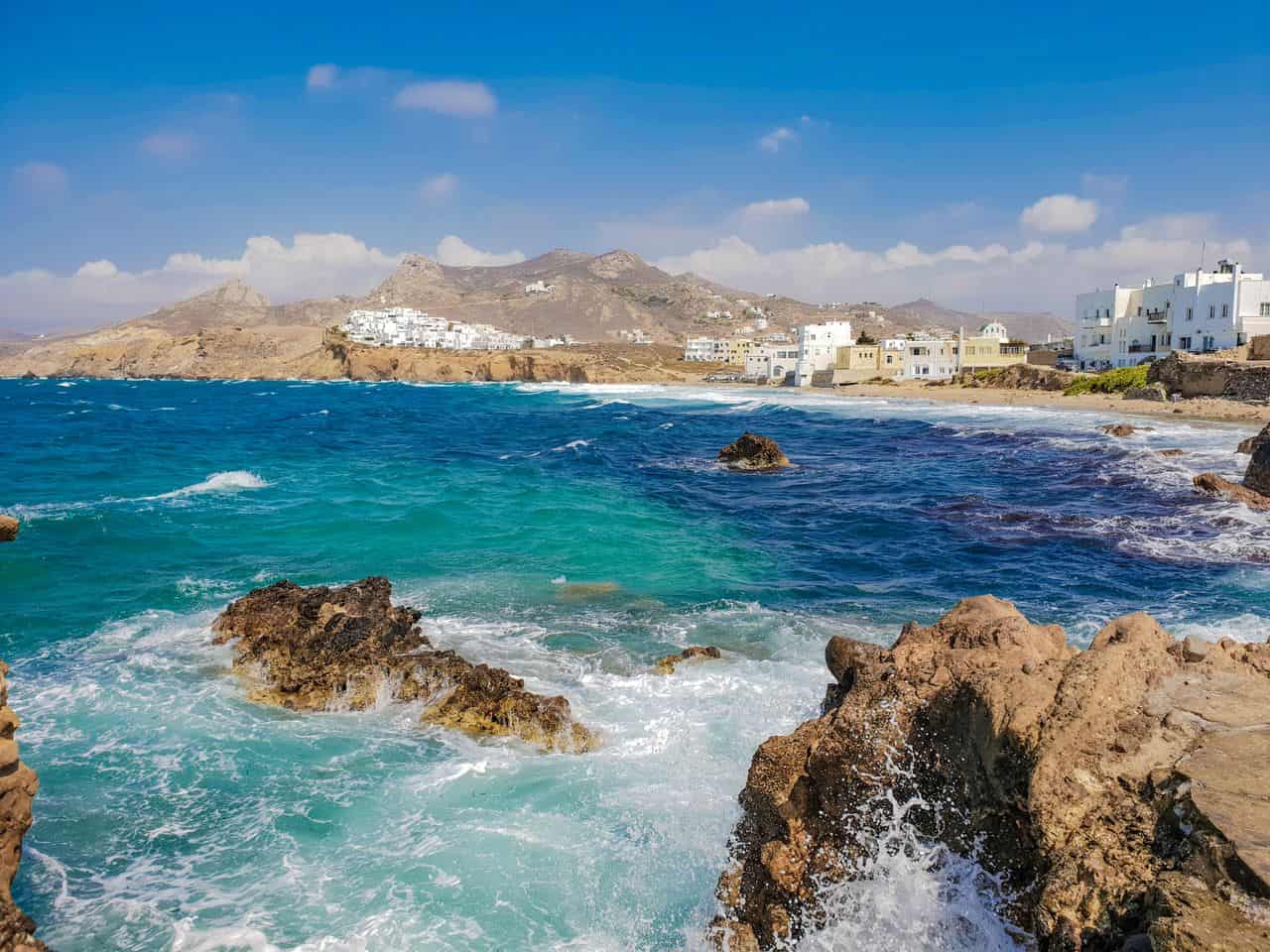 Costa rocosa de Mykonos, Grecia, con aguas turquesas y casas blancas junto al mar Egeo