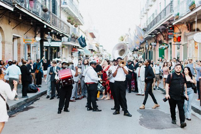 Banda de música desfila entre una multitud por una calle del Barrio Francés de Nueva Orleans.