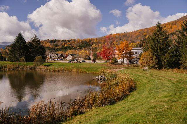 Destino de montaña en Estados Unidos antes del invierno Pueblo de montaña en Estados Unidos rodeado de bosques en otoño, con un lago y colinas al fondo.
