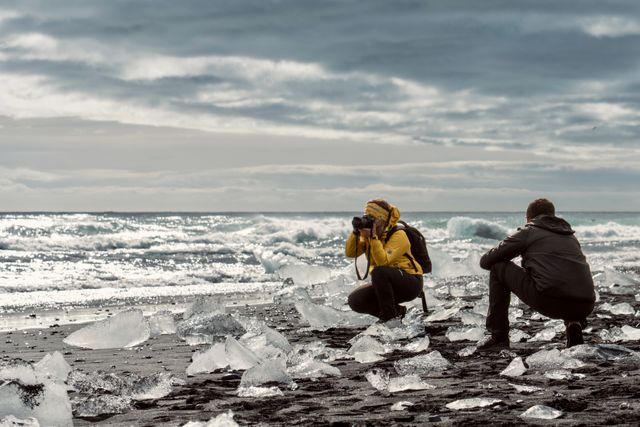 Viajeros fotografían bloques de hielo sobre la arena negra de Diamond Beach, en la costa sur de Islandia.