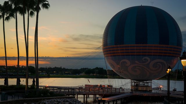 Compras y entretenimiento en Disney Springs, Orlando Globo Aerophile de Disney Springs al atardecer, junto al lago y las palmeras de Orlando.