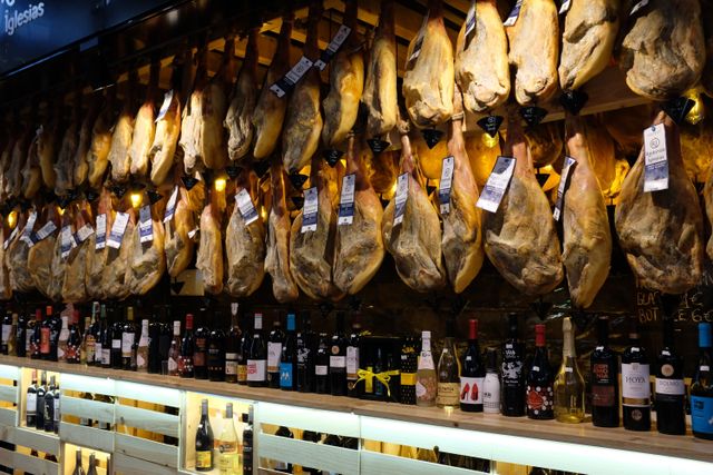 Jamón ibérico en una ruta gastronómica por España Jamones ibéricos colgados en una tienda especializada en España