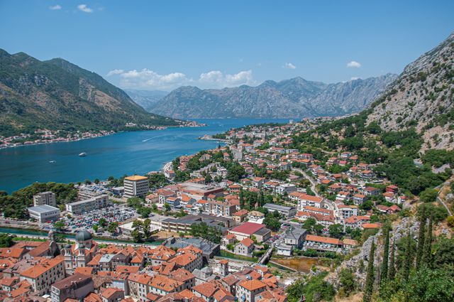 Vista panorámica de Kotor y la bahía de Kotor, en Montenegro, con el casco antiguo, casas de tejados rojos y montañas alrededor.
