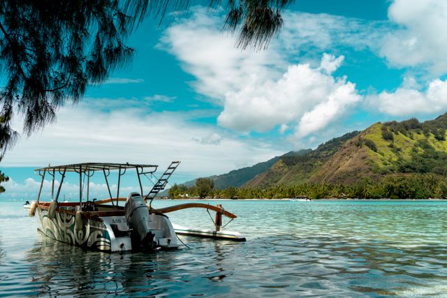 Laguna de aguas turquesas con embarcación y montañas en la Polinesia Francesa
