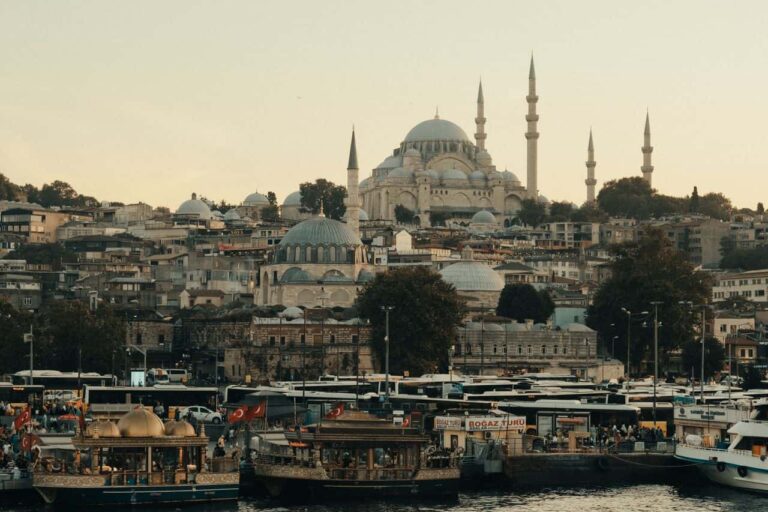 Vista de Estambul desde el agua con embarcaciones, la costa urbana y la mezquita de S&uuml;leymaniye dominando el horizonte.