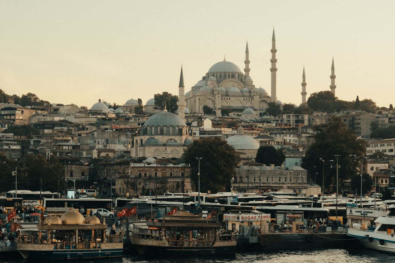 Vista de Estambul desde el agua con embarcaciones, la costa urbana y la mezquita de Süleymaniye dominando el horizonte.